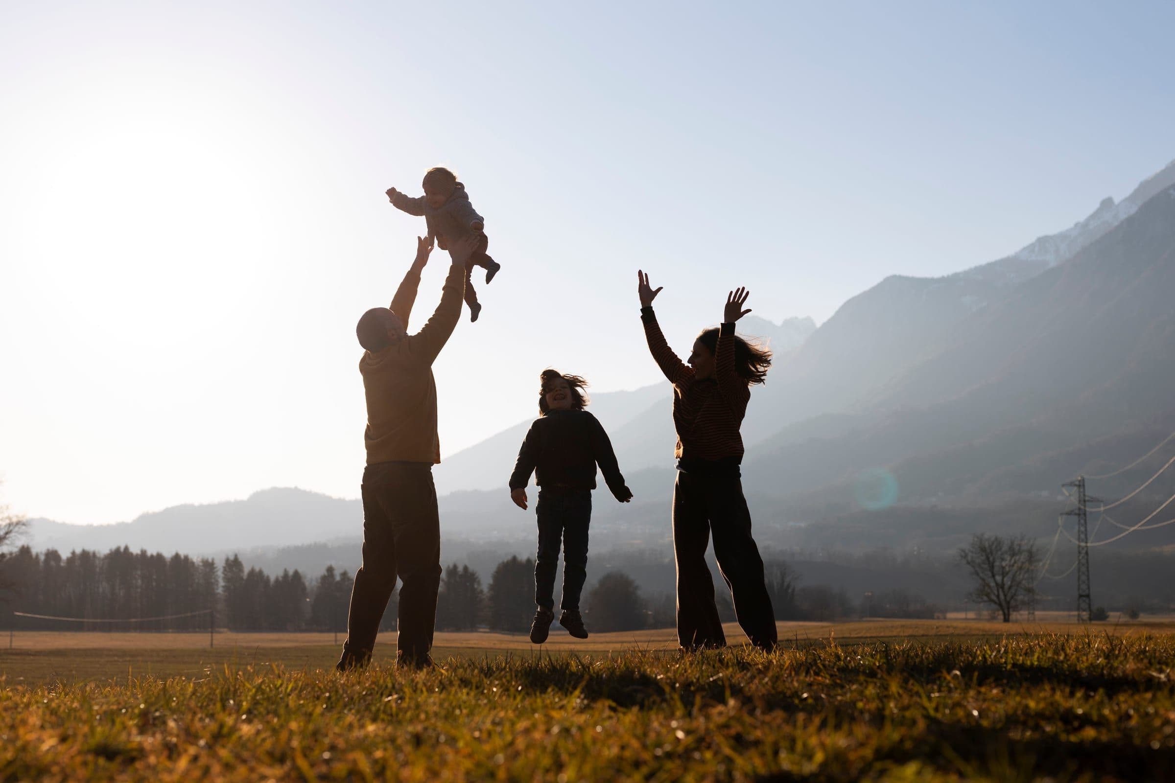 A family silhouetted against the sunset in nature — the values Kalince Holding is built on.