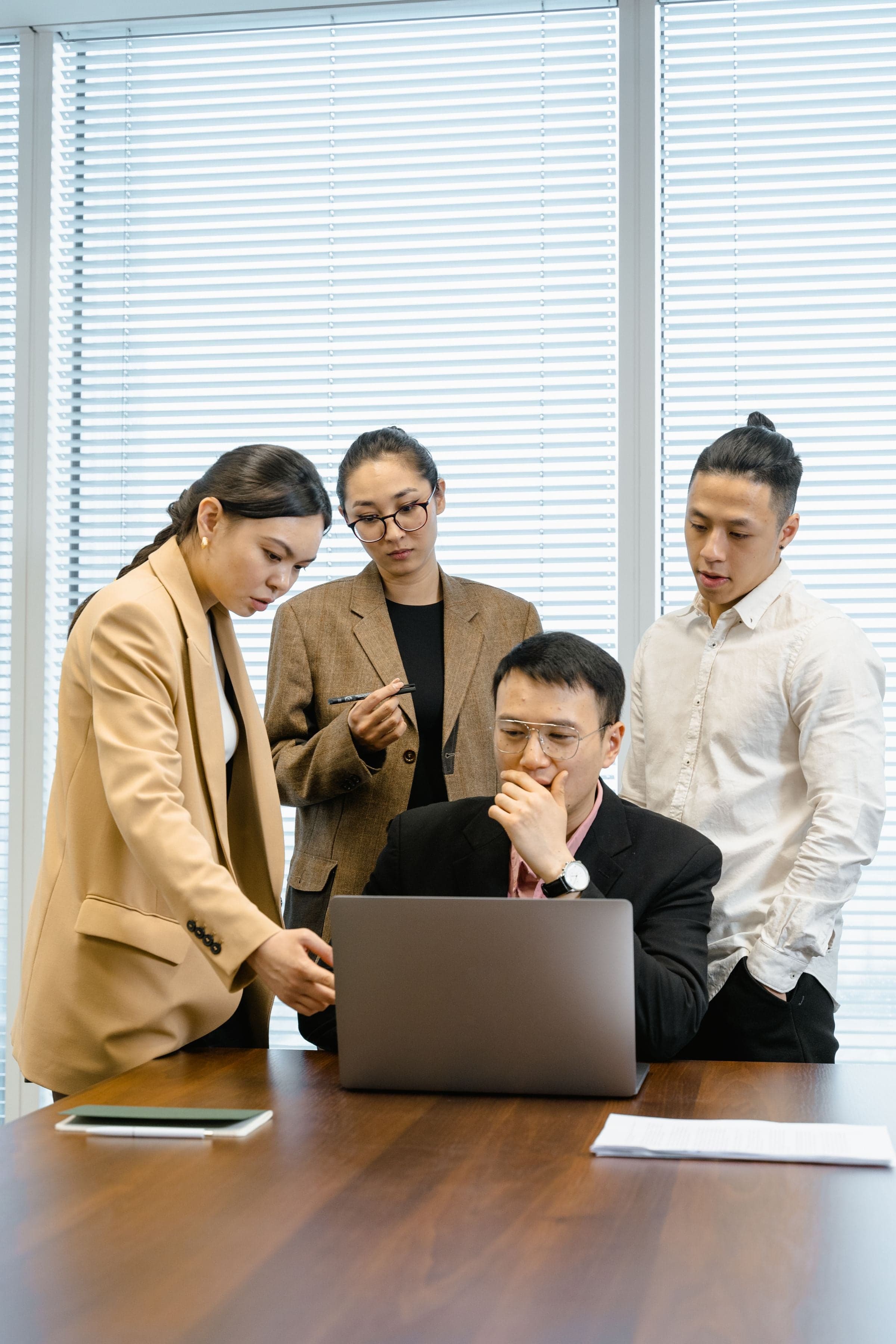 A business team reviewing work together on a laptop.